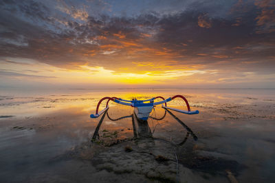 Lifeguard hut on beach against sky during sunset