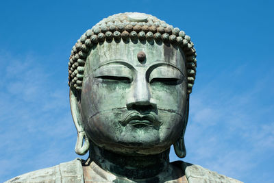 Close-up of statue against blue sky