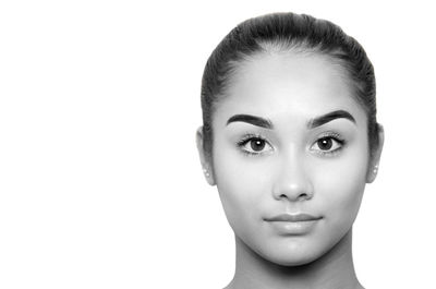 Close-up portrait of young woman against white background