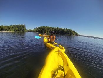 High angle view of woman standing on boat against clear sky
