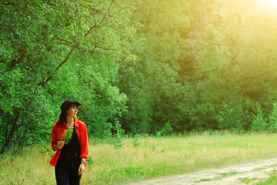 Full length of young woman looking at trees