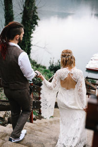 A loving married couple the bride and groom in suits celebrate wedding near the mountains and water