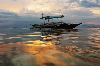 Scenic view of sea against cloudy sky at sunset