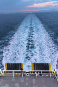 High angle view of ship on sea against cloudy sky during sunset