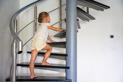 Low angle view of young woman sitting on escalator