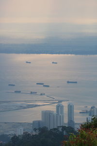 High angle view of buildings by sea against sky