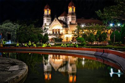 Reflection of illuminated building in pond at night