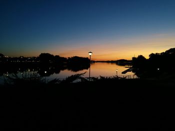 Scenic view of lake against clear sky during sunset