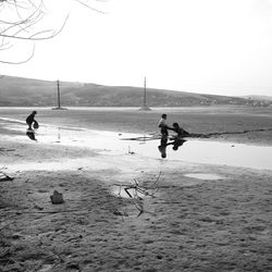 People on beach against clear sky