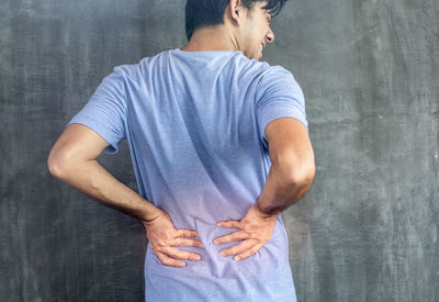 Rear view of man standing against wall