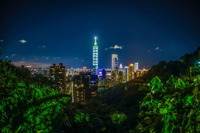 Illuminated cityscape against sky at night