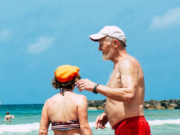 Man with umbrella on beach against sky