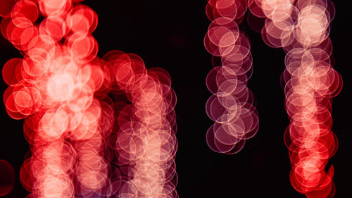 Close-up of illuminated red lights against black background