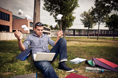 Man using smart phone while sitting on grass