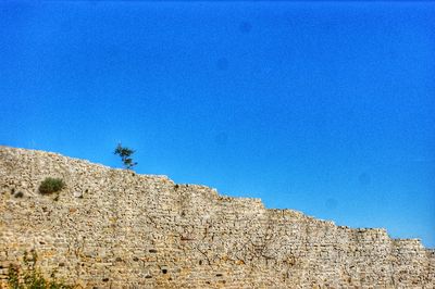 Low angle view of mountain against clear blue sky