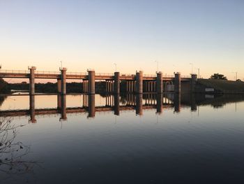 Bridge over river against sky during sunset