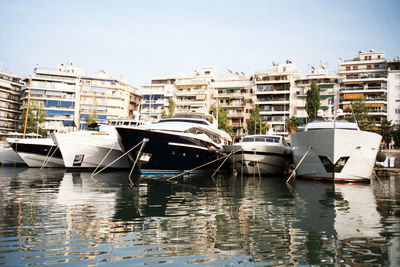 Boats in river with buildings in background