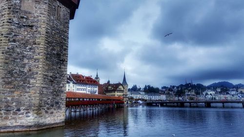 River in city against cloudy sky