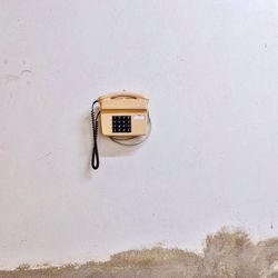 Landline phone hanging on white wall