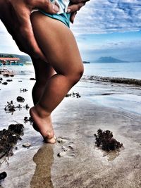 Low section of man standing on beach