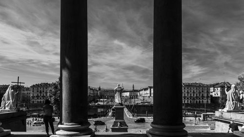 Buildings in city against cloudy sky