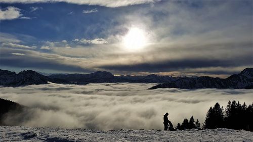 People on snowcapped mountain against sky