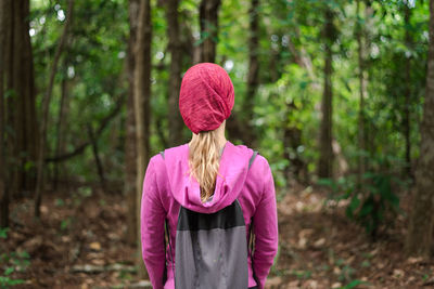 Midsection of woman standing by tree in forest