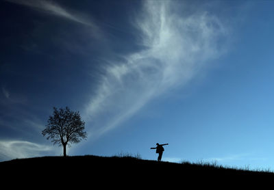 Silhouette person standing on field against sky