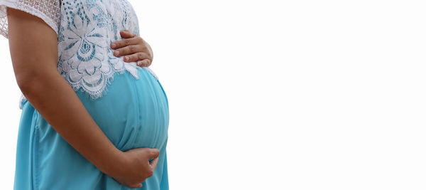 Midsection of woman standing against white background