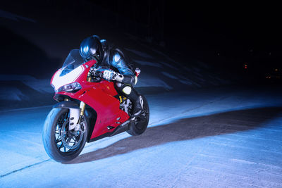 Biker relaxing on motorcycle at night