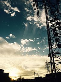 Low angle view of power lines against cloudy sky