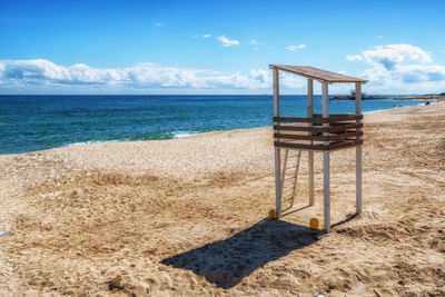 Lifeguard hut on beach against sky