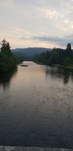 Scenic view of river against sky at sunset