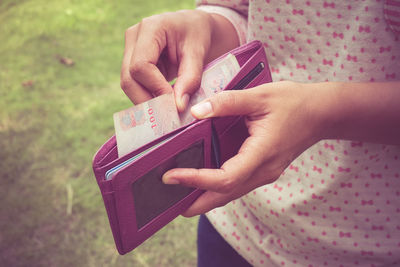 Close-up of hand holding paper currency in wallet