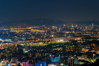 High angle view of illuminated buildings against sky at night