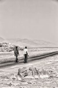 Rear view of people walking on beach