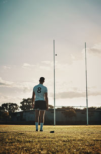 Rear view of man walking on field