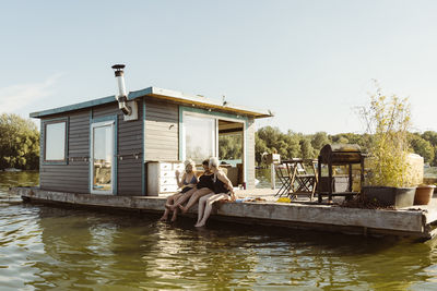 Senior female friends enjoying vacation on houseboat against sky