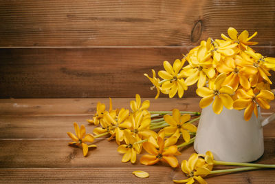 Close-up of yellow flowers on wooden table