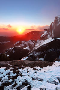 Scenic view of snow covered mountains against sky during sunset