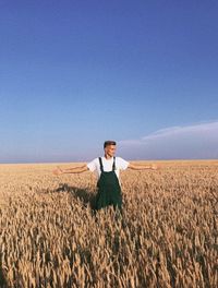 Portrait of man standing on field against sky