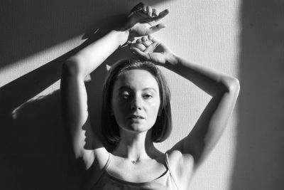 Portrait of young woman against wall