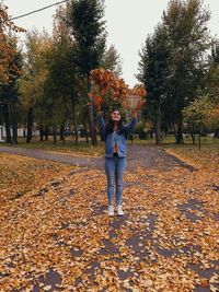 Full length of man standing by leaves during autumn