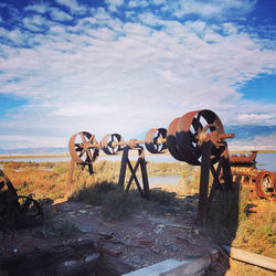 Rusty metallic structure on field against sky
