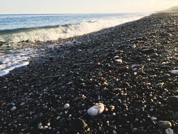 Close-up of pebbles on beach against sky