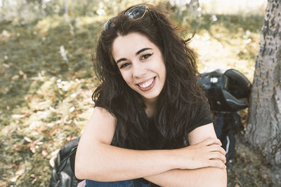 Portrait of young woman sitting on field