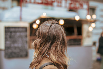 Side view of woman with brown hair in city