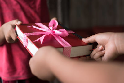 Cropped image of teacher giving gift to student