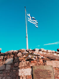Low angle view of flag against clear blue sky