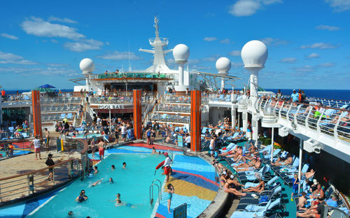 Group of people in swimming pool against sky